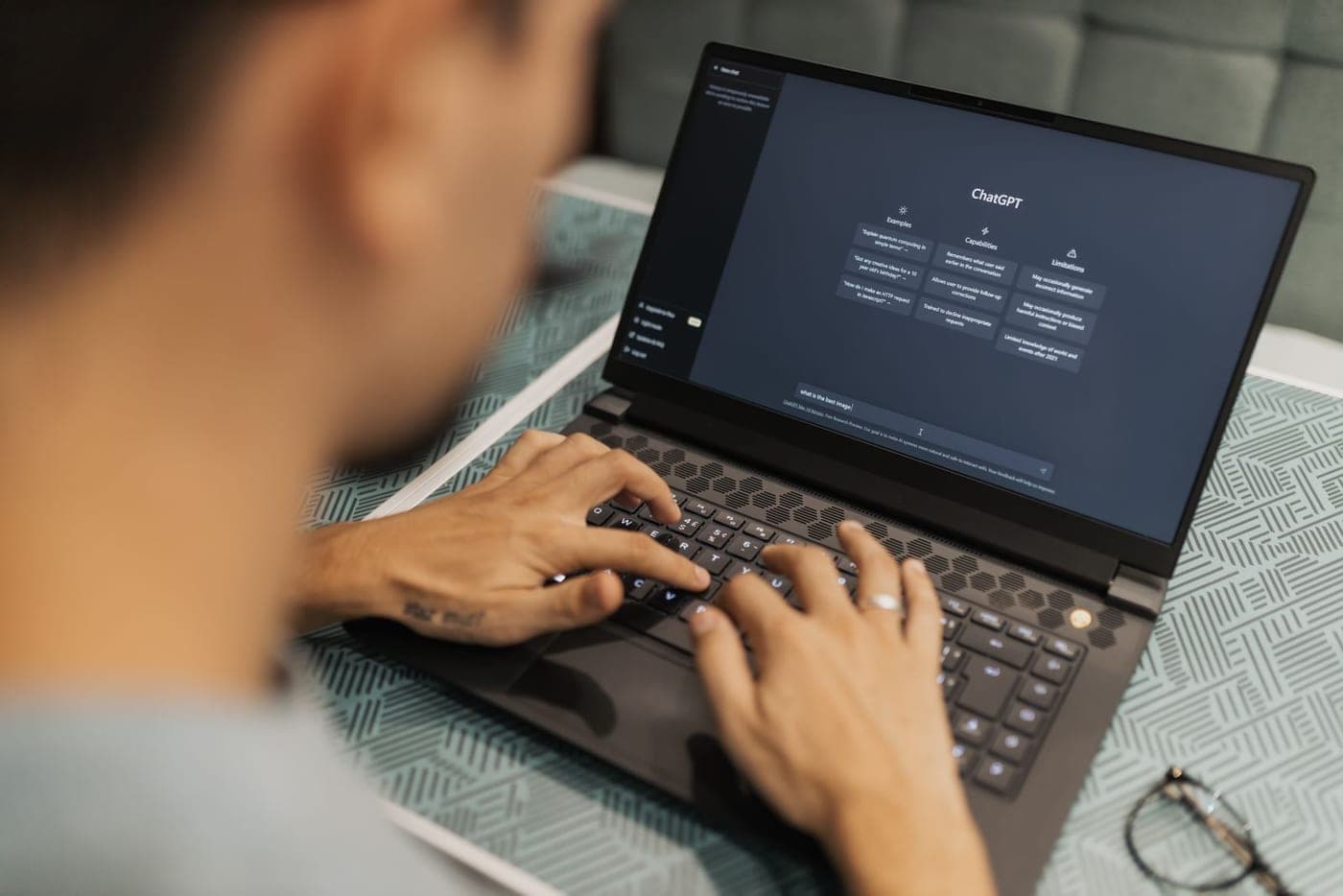 Le mani di una persona digitano su un portatile che mostra l’interfaccia di un software.